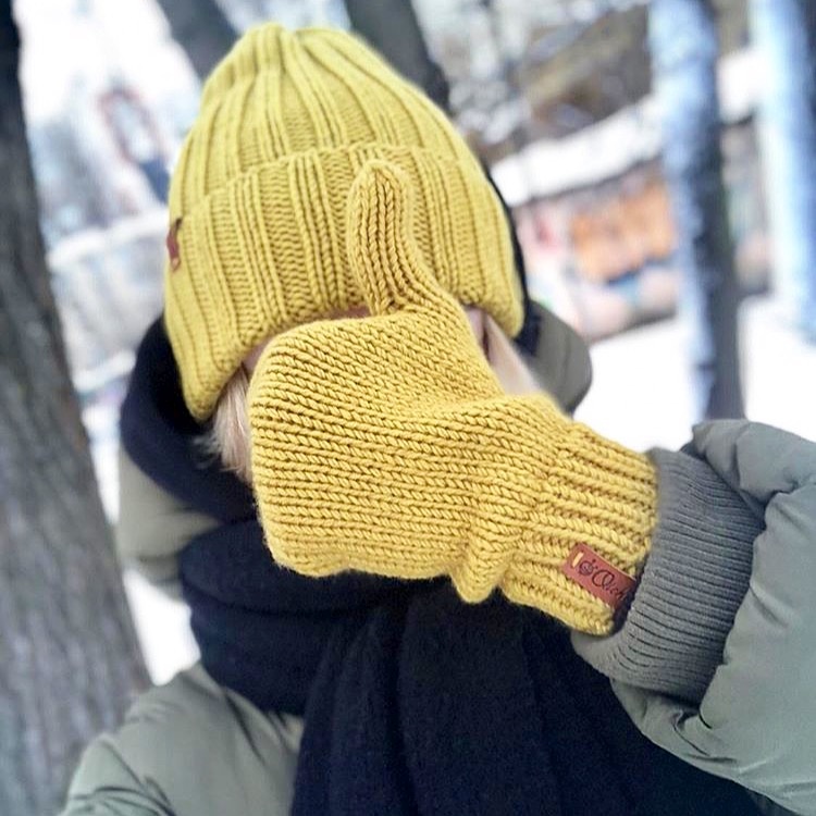 Жёлтые вязаные варежки и шапка на зимней прогулке